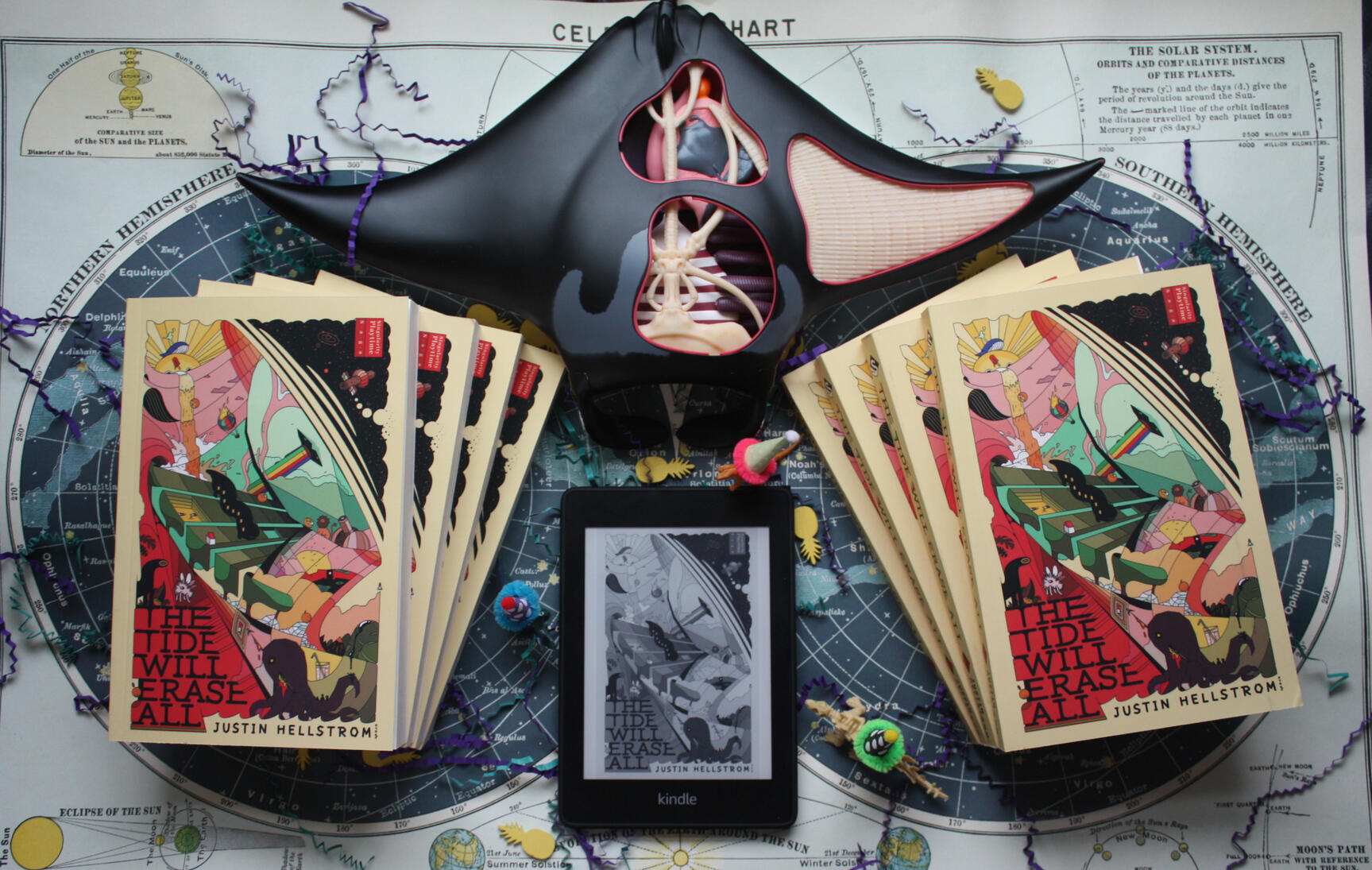 The Tide WIll Erase All Novels, Kindle, on star chart with dinosaurs in party hats and a mantaray model - Singularity Playtime